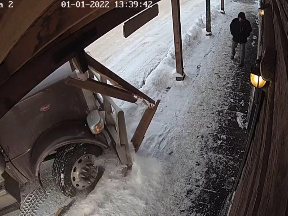 A semi-trailer crashing on to the sidewalk narrowly misses a pedestrian outside a store in downtown Quesnel, B.C.  (Cariboo Keepsakes Local Arts and Crafts  - image credit)