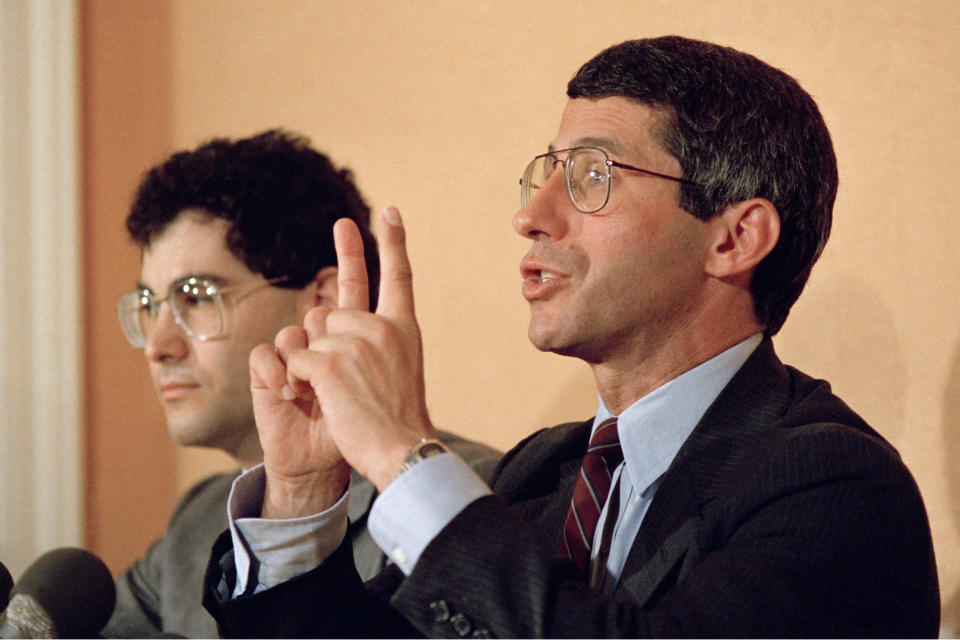 FILE - Dr. Anthony S. Fauci of the National Institute of Health, tells reporters that the first human trial in this country of an experimental vaccine to prevent AIDS, should begin in October, during a news conference in Washington, on Aug. 18, 1987. Franklin Valvovitz, president and chairman of MicroGeneSys, West Haven, Conn., producers of the candidate vaccine, looks on, at left. Fauci steps down from a five-decade career in public service at the end of the month, one shaped by the HIV pandemic early on and the COVID-19 pandemic at the end. (AP Photo/Barry Thumma, File)