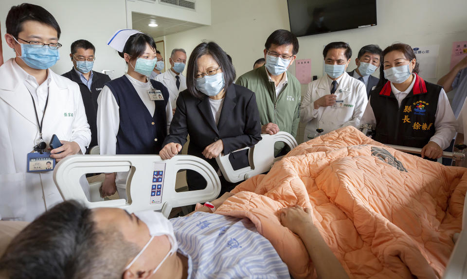 In this photo released by the Taiwan Presidential Office, Taiwan President Tsai Ing-wen visits those injured in Friday's train derailment at a near by hospital in Hualien, eastern Taiwan on Saturday, April 3, 2021. Prosecutors in Taiwan on Saturday sought an arrest warrant for the owner of an unmanned truck that rolled onto a train track and caused the country's worst rail disaster in decades, killing dozens and injuring more.(Taiwan Presidential Office via AP)