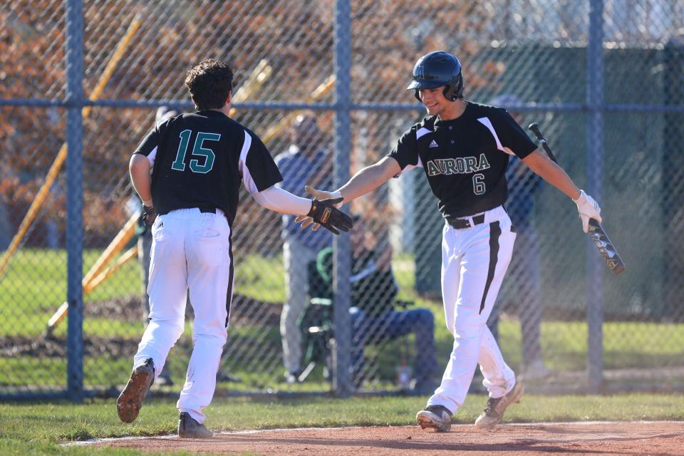 Aurora junior Sam Retton and senior Ryan Weber celebrate a run during a game against Kent Roosevelt. Weber was named the Suburban League American Conference Player of the Year and All-Ohio first team.