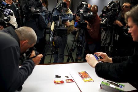 News crews photograph pieces of shrapnel taken from the body of Boston Marathon bombing victim Krystle Campbell and presented as evidence in the trial of Dzhokhar Tsarnaev in Boston, Massachusetts March 26, 2015. REUTERS/Brian Snyder