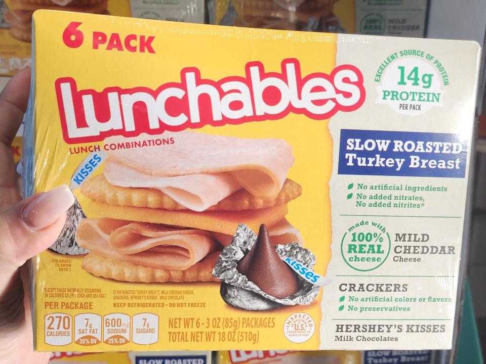The writer holds a six-pack of Lunchables