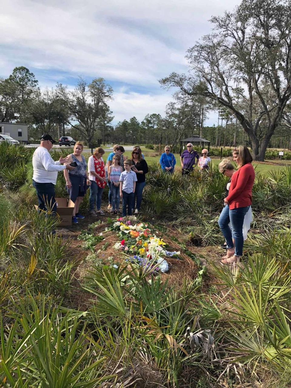 Mourners lay flowers on a freshly filled grave at Heartwood Preserve Conservation Cemetery near Tampa, Florida.