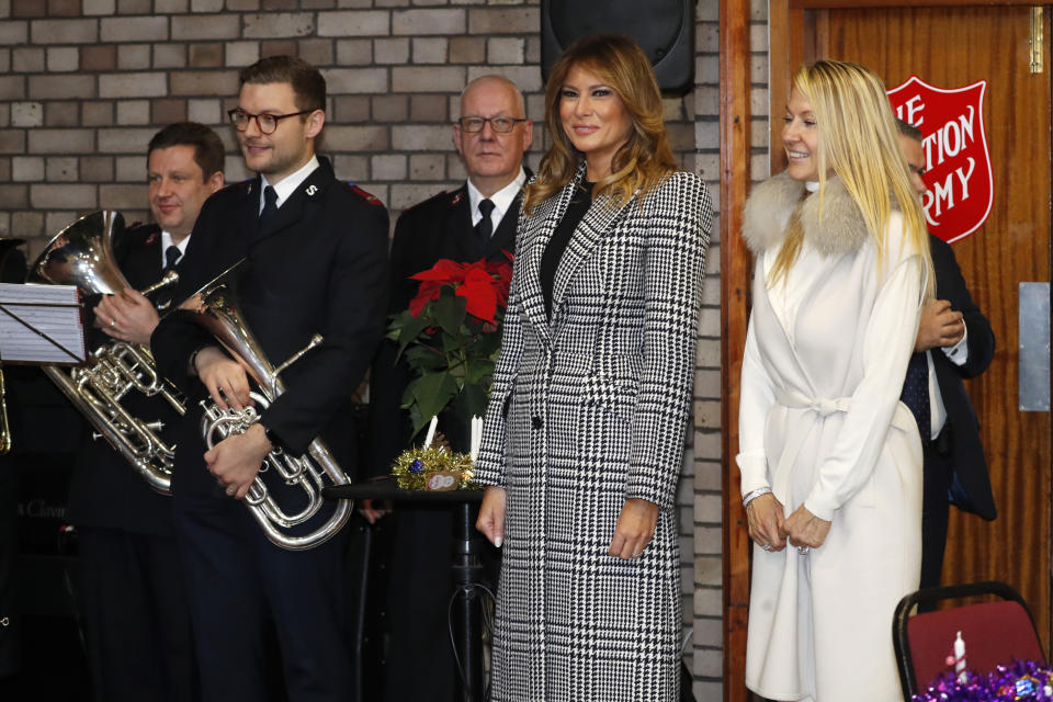 First lady Melania Trump and Suzanne Johnson, wife of the US ambassador to Britain, right, listen to a children choir after joining local students wrapping holiday presents to be donated to the Salvation Army, at the Salvation Army Clapton Center in London, Wednesday, Dec. 4, 2019. (AP Photo/Alastair Grant, Pool)