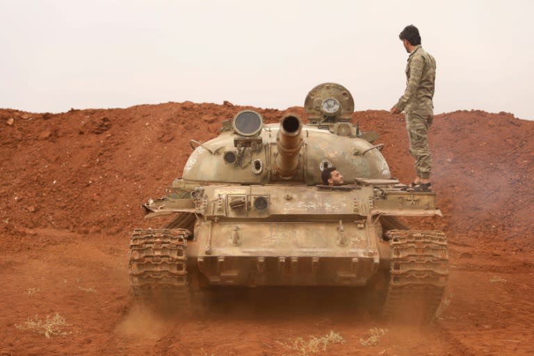 Syrian rebels of the Turkish-backed National Liberation Front reposition a tank on October 9, 2018 after moving it from territory earmarked for a buffer zone between rebel and government forces