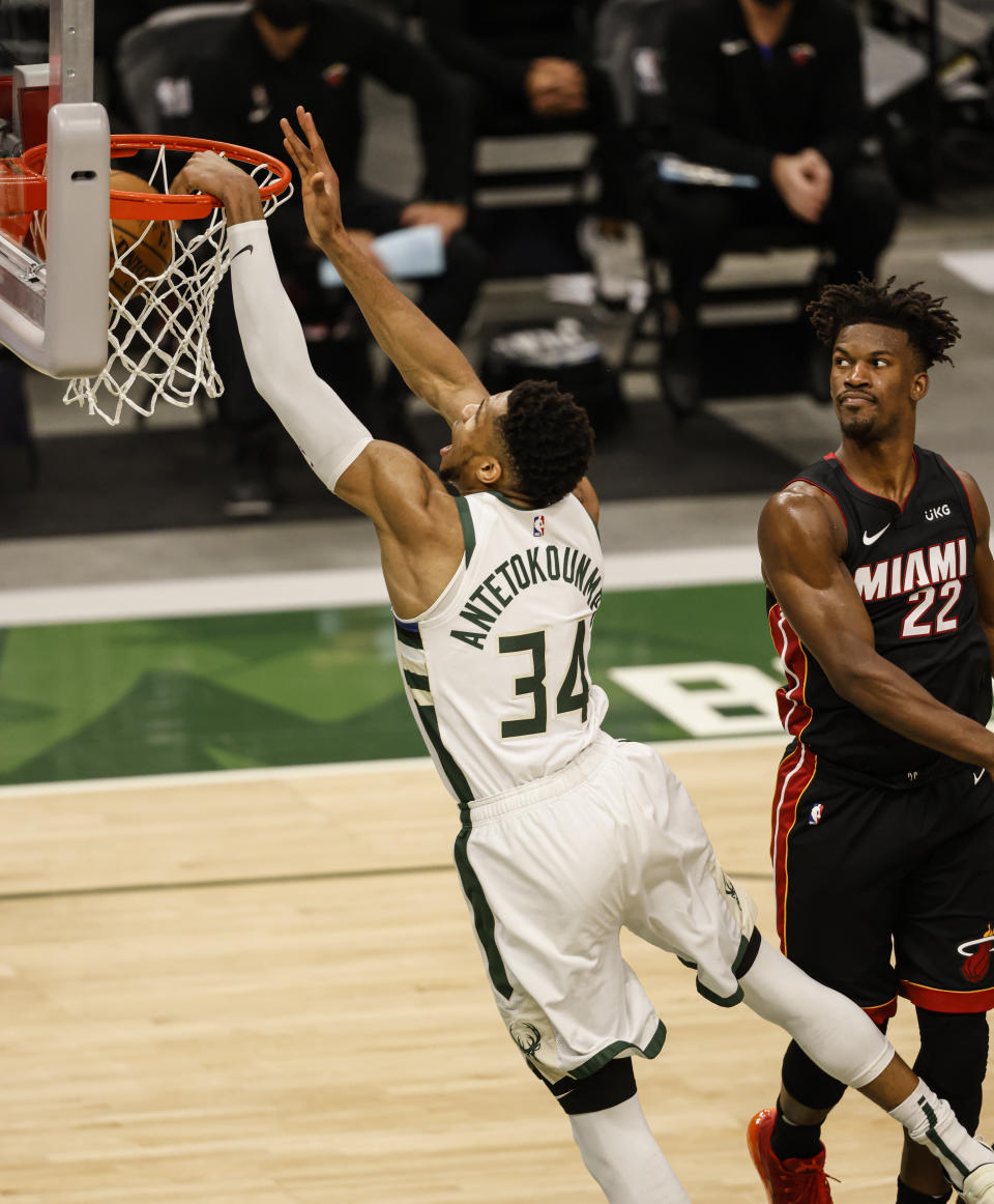 Milwaukee Bucks forward Giannis Antetokounmpo (34) dunks as Miami Heat forward Jimmy Butler (22) watches during the second half of Game 2 of their NBA basketball first-round playoff series Monday, May 24, 2021, in Milwaukee. (AP Photo/Jeffrey Phelps)