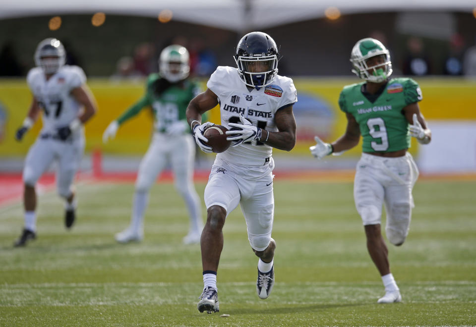 Utah State wide receiver Jalen Greene (21) sprints to the end zone to score a touchdown ahead of North Texas defensive back Nate Brooks (9) during the first half of the New Mexico Bowl NCAA college football game in Albuquerque, N.M., Saturday, Dec. 15, 2018. (AP Photo/Andres Leighton)