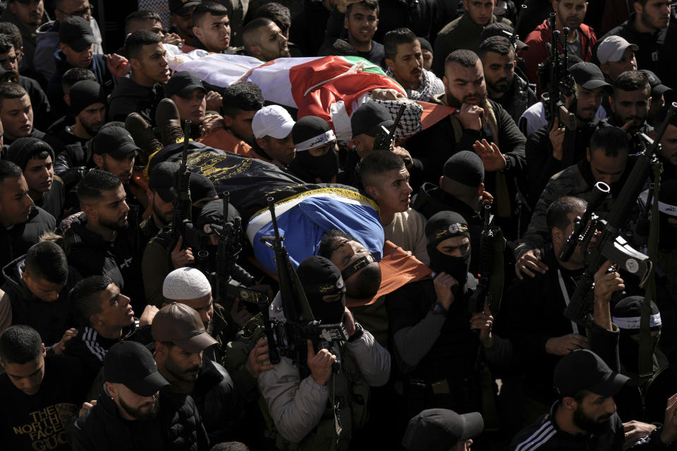 Palestinian mourners carry the bodies of secondary school teacher Jawad Bawaqna, 57, right, and Adham Jabareen, 28, during their funeral in the in the West Bank city of Jenin, Thursday, Jan. 19, 2023. Palestinian officials and media reports say Israeli troops shot and killed the Palestinian schoolteacher and a militant during a military raid in the occupied West Bank. (AP Photo/Majdi Mohammed)