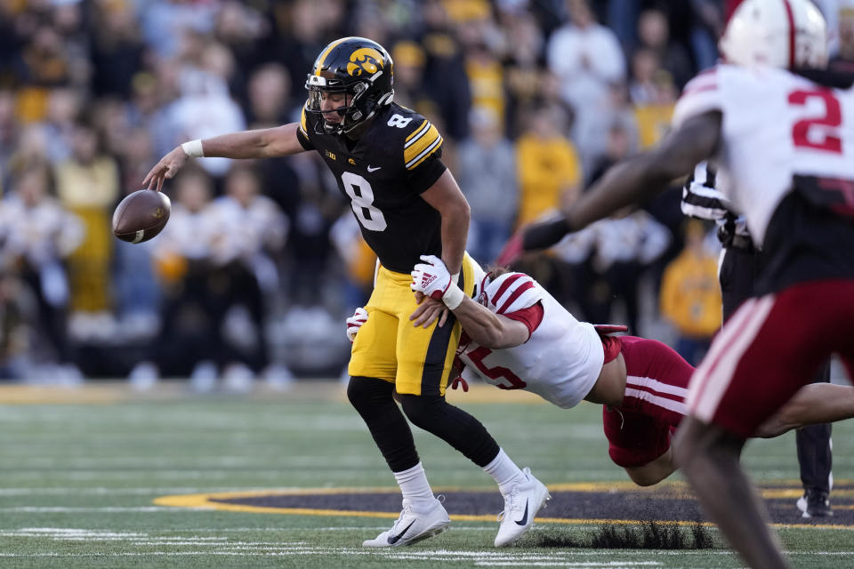 Iowa quarterback Alex Padilla (8) fumbles as he is tackled by Nebraska linebacker Eteva Mauga-Clements (5) during the first half of an NCAA college football game, Friday, Nov. 25, 2022, in Iowa City, Iowa. (AP Photo/Charlie Neibergall)