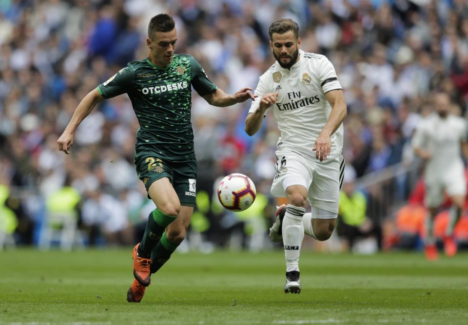 Betis player Lo Celso, left, duels for the ball against Real Madrid's Nacho Fernanzez during a Spanish La Liga soccer match at the Santiago Bernabeu stadium in Madrid, Spain, Sunday, May 19, 2019. (AP Photo/Bernat Armangue)