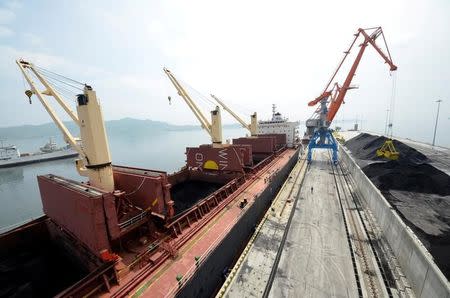 FILE PHOTO - A cargo ship is loaded with coal during the opening ceremony of a new dock at the North Korean port of Rajin July 18, 2014. REUTERS/Yuri Maltsev/File Photo