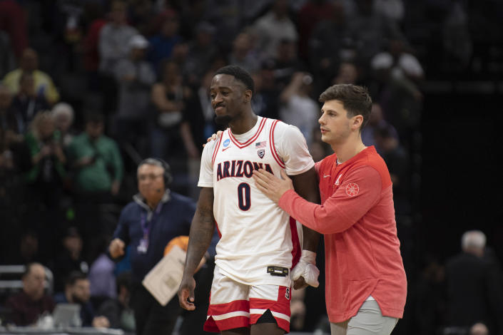 Arizona guard Courtney Ramey (0) is consoled as he leaves the floor following a first-round college basketball game loss to Princeton in the NCAA Tournament in Sacramento, Calif., Thursday, March 16, 2023. Princeton won 59-55. (AP Photo/José Luis Villegas)