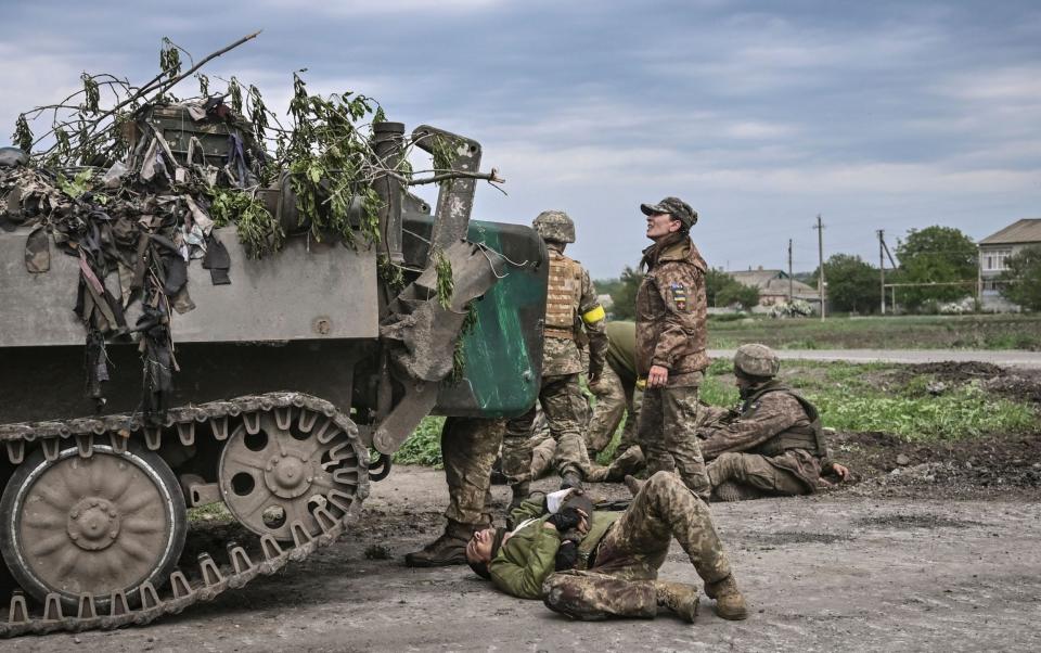 Ukrainian troops assist their comrades near the front line in the eastern Ukraine region of Donbas, which is now the focus of the war