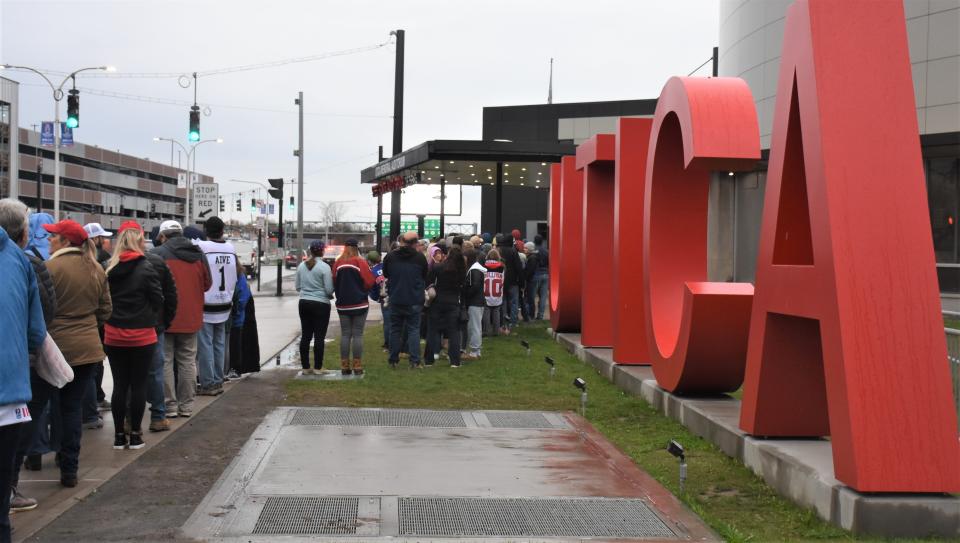 Fans lined up along Oriskany Street wait for the Adirondack Bank Center gates to open for the International Ice Hockey Federation gold medal game between the United States and Canada Sunday.