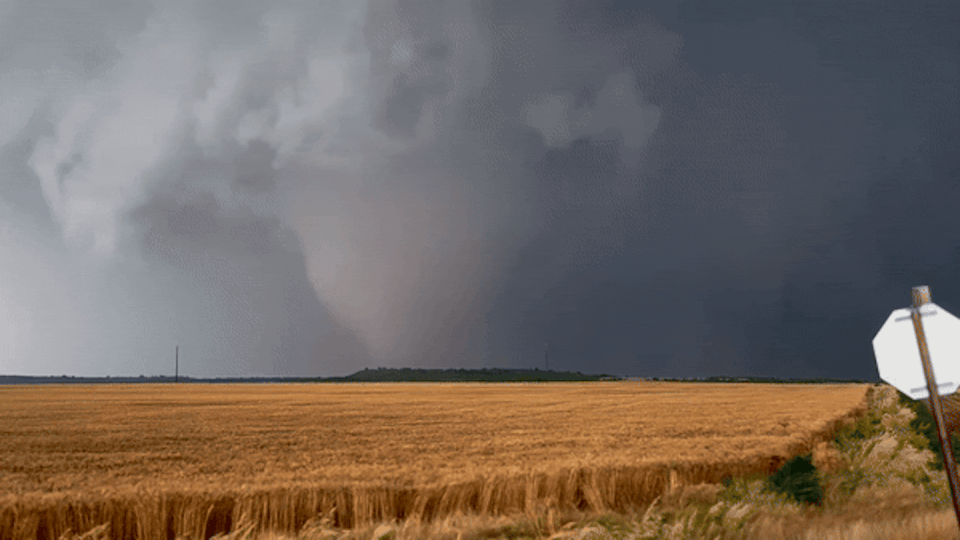 A tornado near Duke, Oklahoma, with a wheat field blowing in the foreground.