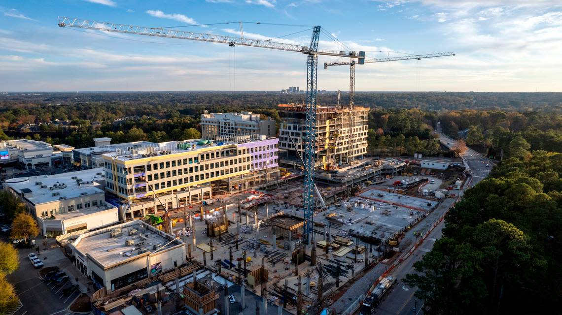 Construction cranes tower over new towers under construction at North Hills in Raleigh Monday, Nov. 14, 2022. The skyline of downtown Raleigh is visible in the background at the center of the horizon.