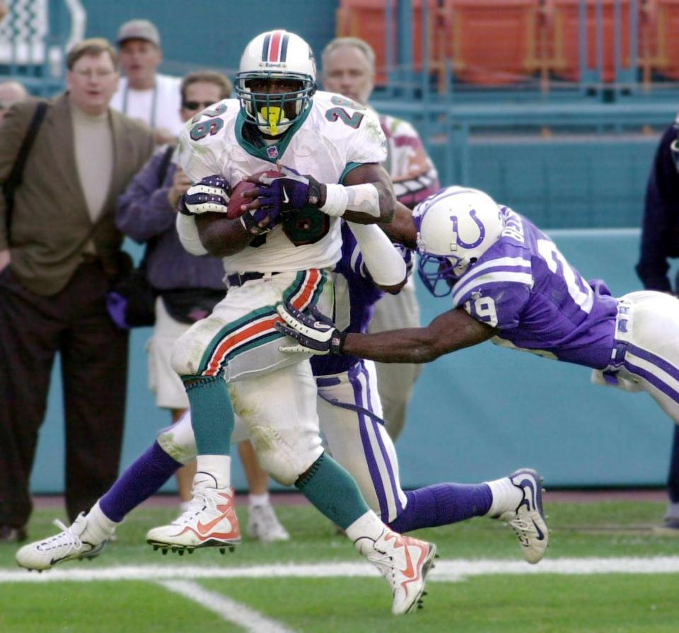 Miami Dolphins' running back Lamar Smith scores (L) the winning touchdown in overtime against the Indianapolis Colts 30 December 2000 in their Wild Card Playoff game at Pro Player Stadium in Miami, FL. The Dolphins won the game 23-17.