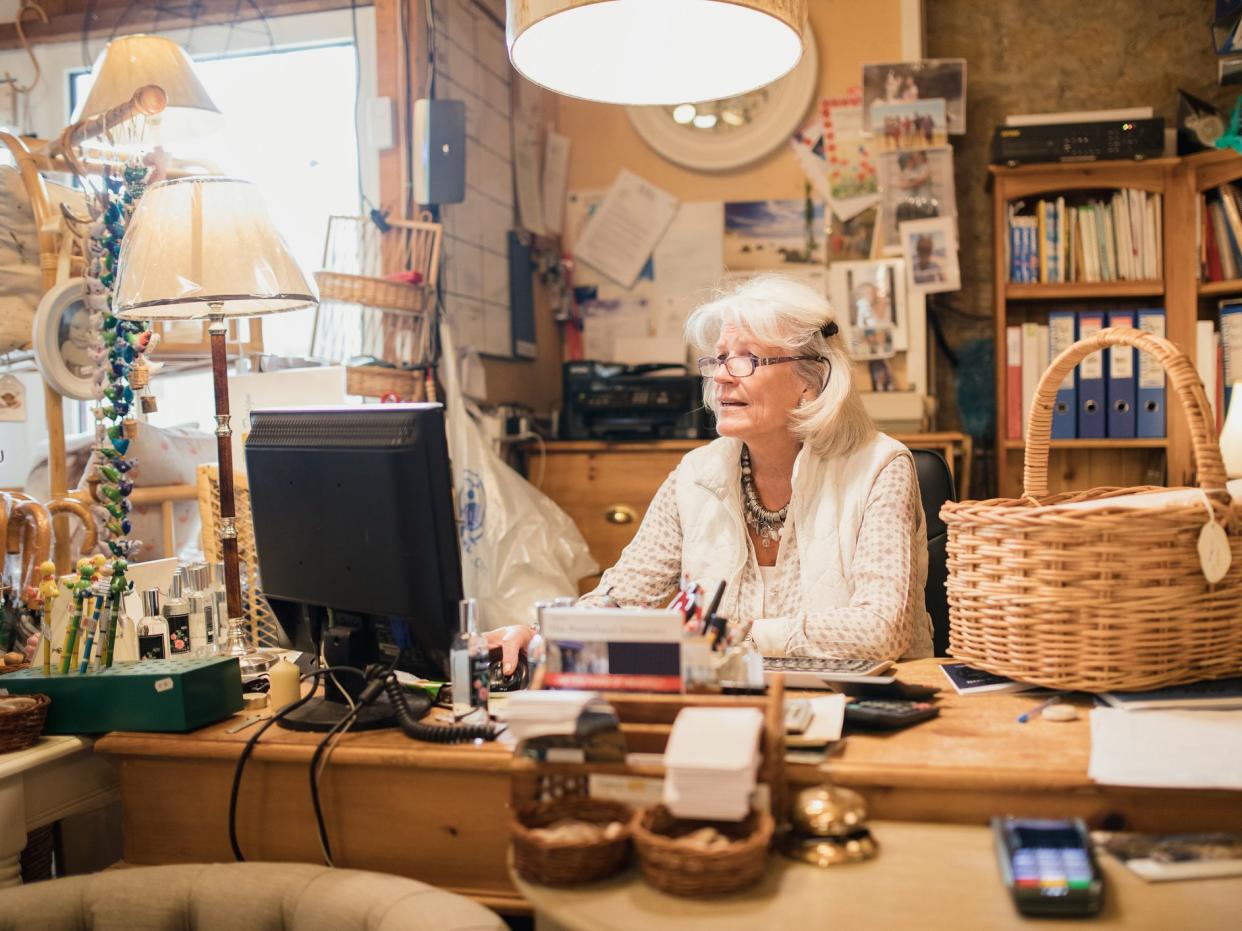 Senior woman entrepreneur working on the computer in the furniture store.