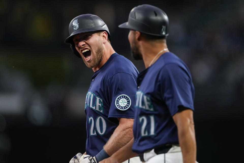 Seattle Mariners' Luke Raley reacts with first base coach Kristopher Negrón, right, after tying the game by hitting an RBI single against the Chicago White Sox during the eighth inning of a baseball game, Monday, June 10, 2024, in Seattle. (AP Photo/Lindsey Wasson)