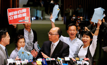 Pro-democracy lawmakers chant slogans against Secretary for Transport and Housing Frank Chan (C), after Legislative Council passed a controversial bill to introduce mainland Chinese laws inside an upcoming high-speed rail station, in Hong Kong, China June 14, 2018. REUTERS/Bobby Yip