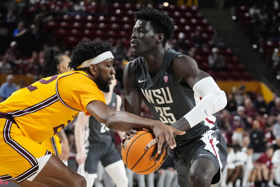 Washington State forward Mouhamed Gueye (35) gets fouled by Arizona State forward Warren Washington, left, during the first half of an NCAA college basketball game in Tempe, Ariz., Thursday, Jan. 5, 2023. (AP Photo/Ross D. Franklin)