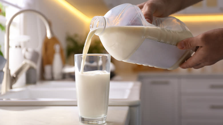 person pouring glass of milk