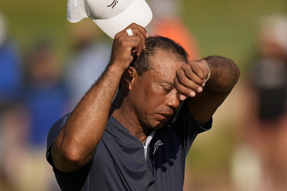 Tiger Woods wipes his face on the 16th hole during weather warnings in second round of the U.S. Open golf tournament Friday, June 14, 2024, in Pinehurst, N.C. (AP Photo/Mike Stewart)