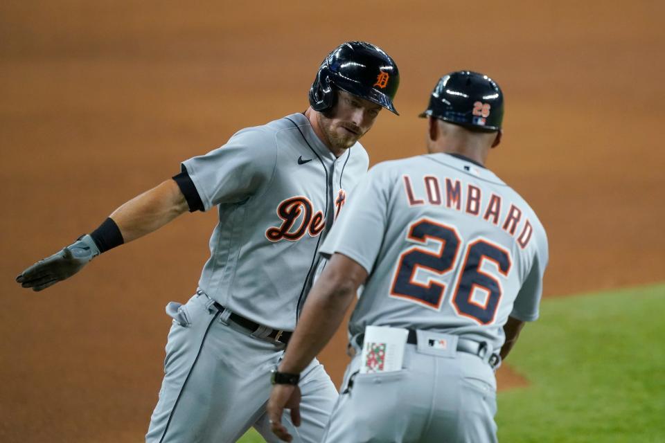 Tigers left fielder Robbie Grossman, left, and third base coach George Lombard, right, celebrate a solo home run by Grossman in the fourth inning in Arlington, Texas, Tuesday, July 6, 2021.