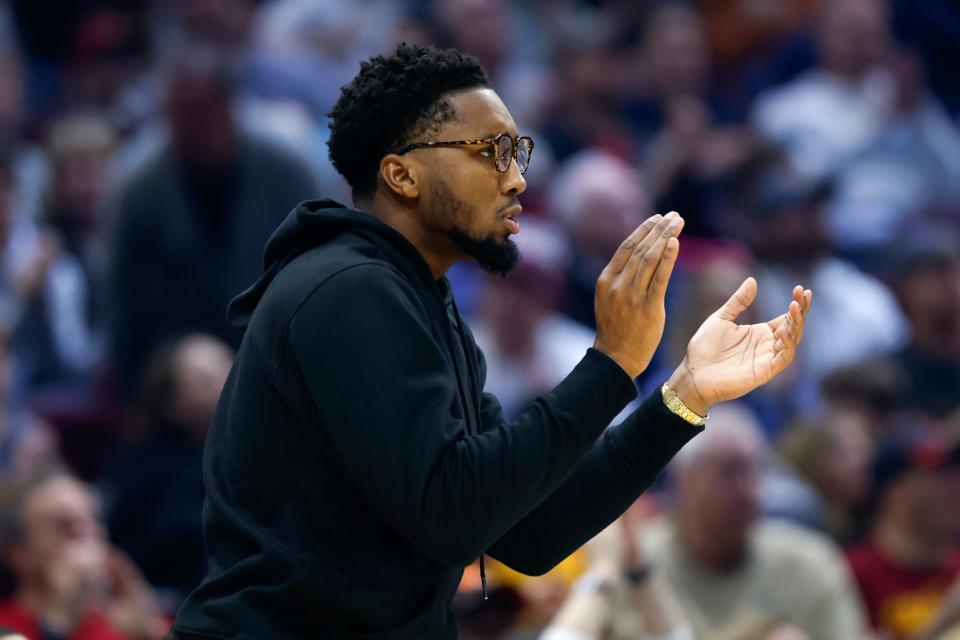 Injured Cleveland Cavaliers guard Donovan Mitchell cheers from the bench during the first half of an NBA basketball game against the Minnesota Timberwolves, Sunday, Nov. 13, 2022, in Cleveland. (AP Photo/Ron Schwane)