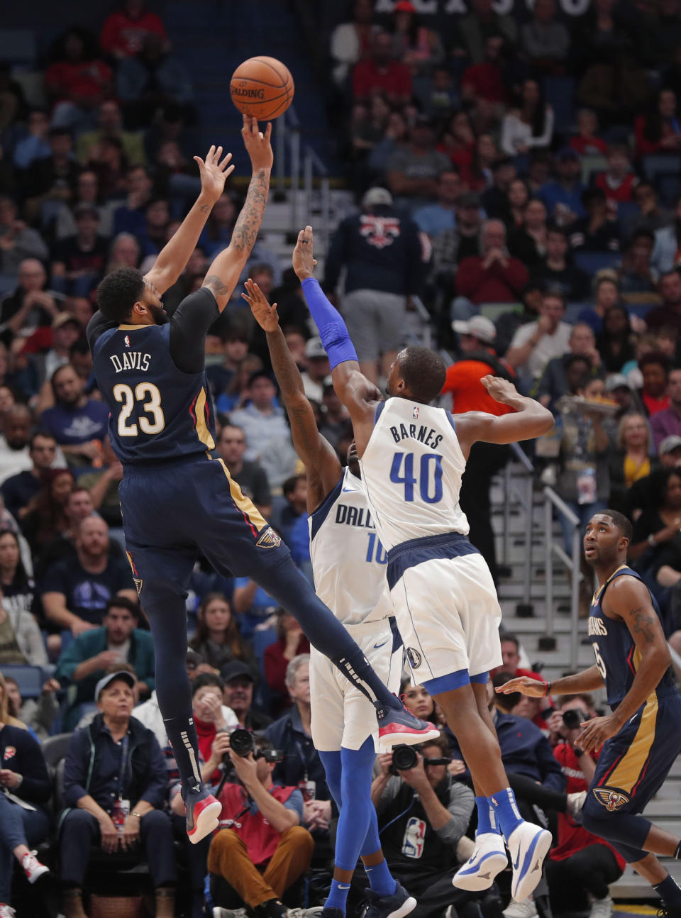 New Orleans Pelicans forward Anthony Davis (23) shoots as Dallas Mavericks forwards Dorian Finney-Smith (10) and Harrison Barnes (40) defend during the first half of an NBA basketball game in New Orleans, Friday, Dec. 28, 2018. (AP Photo/Gerald Herbert)