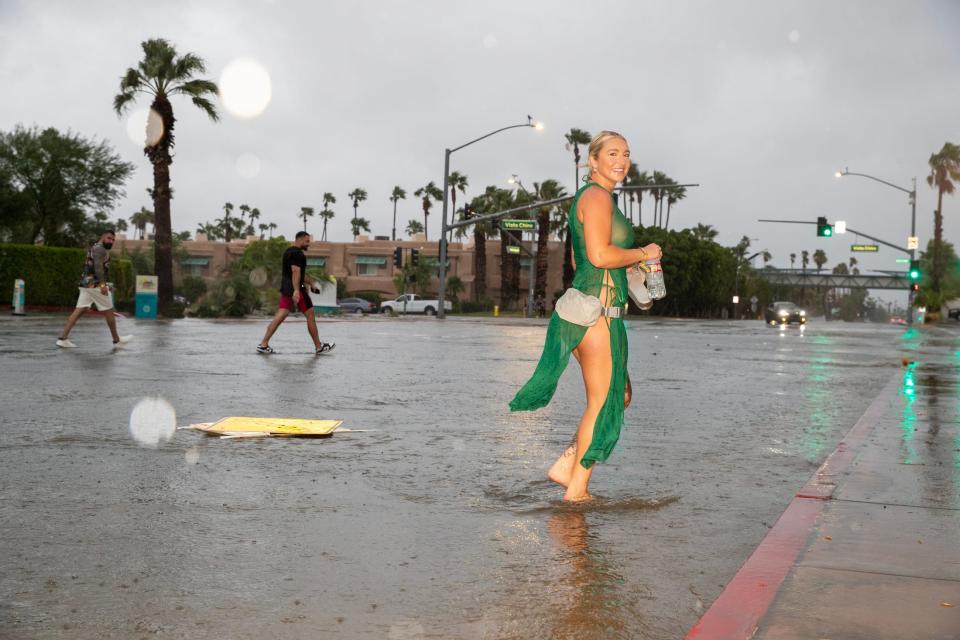 Splash House festival goer Caitlin Tropp of San Diego walks barefoot in flood waters from Tropical Storm Hilary in Palm Springs, Calif., on Sunday, August 20, 2023.