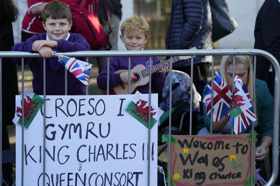 Children wait for the arrival of the King Charles III and the Queen Consort in Cardiff, Wales, Friday, Sept. 16, 2022. The Royal couple will visit Wales for the first time since the death of Queen Elizabeth II. (AP Photo/Frank Augstein)