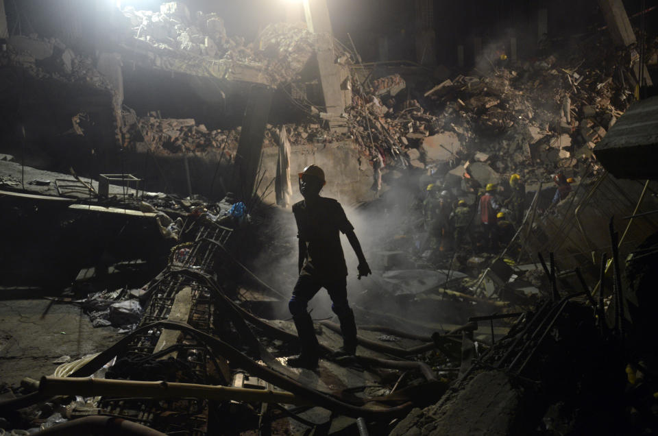 In this Monday, April 29, 2013 file photo, a Bangladeshi worker leaves the site where a garment factory building collapsed in the Savar area on the outskirts of Dhaka, Bangladesh. After more than 1,100 people died when a garment factory complex collapsed in Dhaka, Bangladesh authorities imposed more stringent safety rules. But corruption and lax enforcement have resulted in many more deaths linked to safety lapses since the 2013 Rana Plaza disaster, including a fire Thursday in an illegally-constructed high-rise office building that killed at least 25 people and left dozens more injured. (AP Photo/Ismail Ferdous, File)