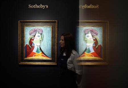 A Sotheby's employee poses with Pablo Picasso's artwork "Tete de femme" at Sotheby's auction house in London October 11, 2013. The artwork, with an estimated value of $20-30 million, forms part of the exhibition "Frieze Week" and will be auctioned in New York on November 6. REUTERS/Stefan Wermuth
