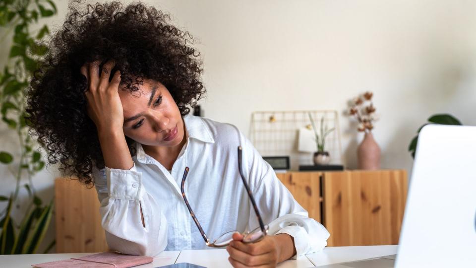 Young African American woman feeling exhausted and depressed sitting in front of laptop. Work burnout syndrome. Mental Health concept.