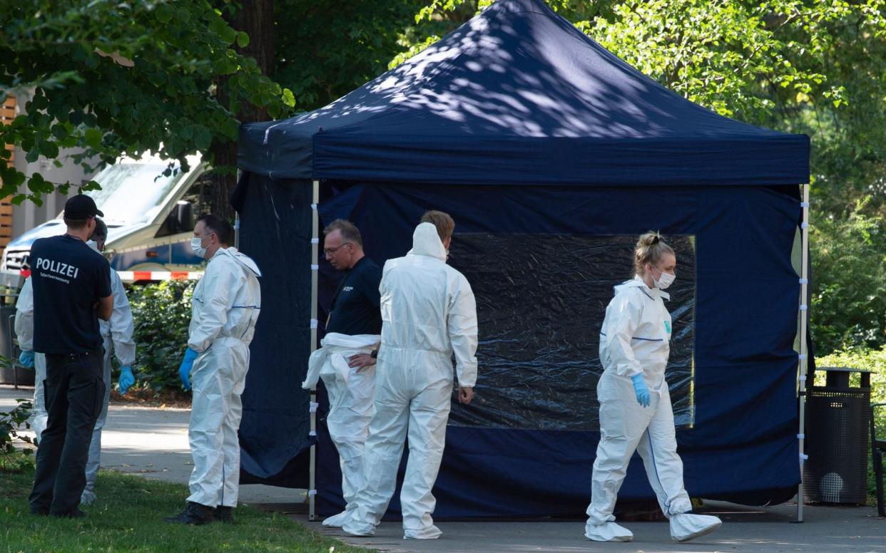 Forensic experts scour the crime scene in a park in Berlin's Moabit district - DPA