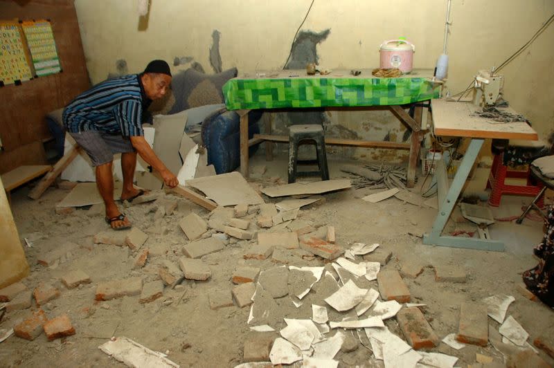 A resident shows a damaged house after an earthquake struck off the Indonesian island of Java in Pagedangan