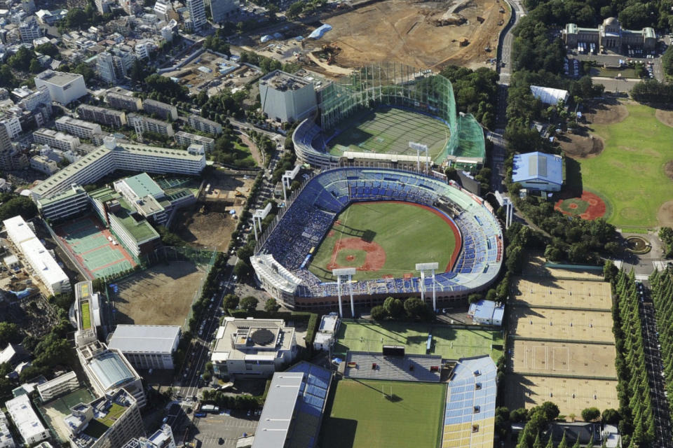 This photo shows the Meiji Jingu Stadium, center, in Tokyo on July 22, 2015. Above the Meiji baseball stadium is Jingu Daini, or Second, Stadium, the Chichibunomiya rugby stadium, bottom, and a construction site for the National Stadium, top, used for the 2020 Summer Olympics, which were postponed to 2021 due to the coronavirus pandemic. (Kyodo News via AP)