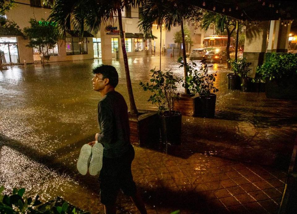 A man looks at the rain as streets flood in Brickell, Miami, on Wednesday, Nov. 16, 2023. Ashley Miznazi/amiznazi@miamiherald.com