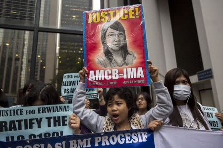 A supporter holds up a sign with a drawing of Indonesian domestic helper Erwiana Sulistyaningsih, during a protest calling for better protection of migrant workers, outside the district court in Hong Kong February 27, 2015. REUTERS/Tyrone Siu