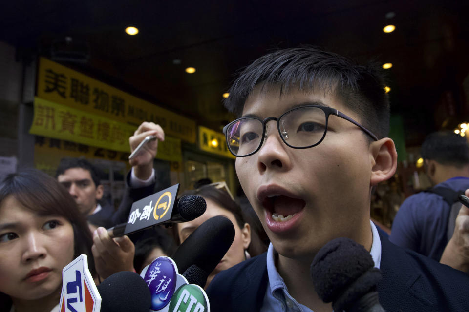 Pro-democracy activist Joshua Wong speaks to journalists outside of a polling place in Hong Kong, Sunday, Nov. 24, 2019. Voting was underway Sunday in Hong Kong elections that have become a barometer of public support for anti-government protests now in their sixth month. (AP Photo/Ng Han Guan)