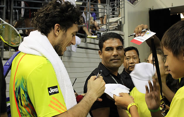 Juan Monaco was an entertaining player and immediately became a crowd favourite for his on-court antics. Here, Monaco signs his autograph for the ball boys and girls. (Yahoo! photo/Melissa Law)