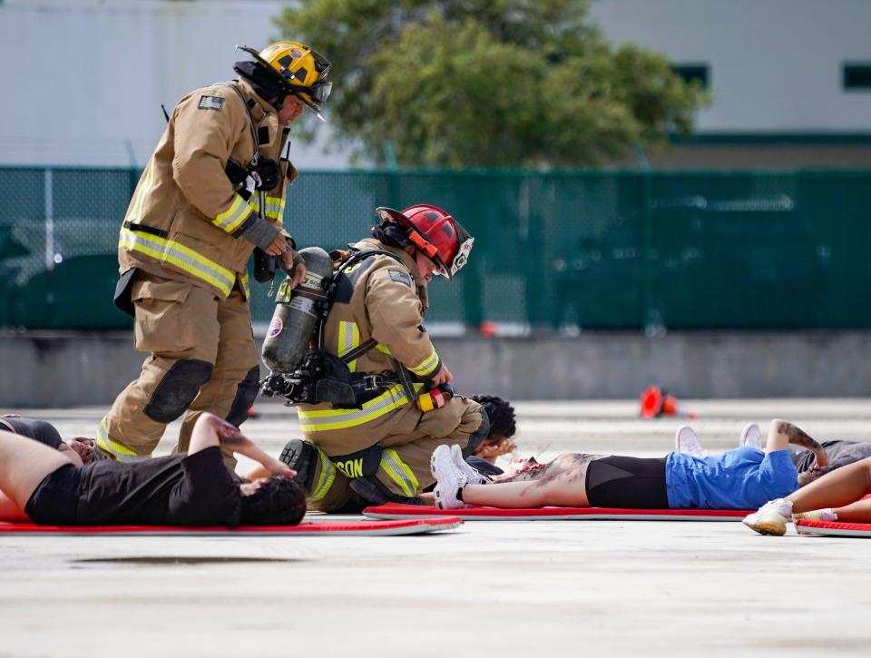 Firefighters care for Lorenzo Walker Technical College Cosmetology program students during a simulated disaster exercise at Naples Airport on Tuesday, April 25, 2023. The students used their makeup skills to represent various injuries first responders may come across when responding to an airplane-related incident.