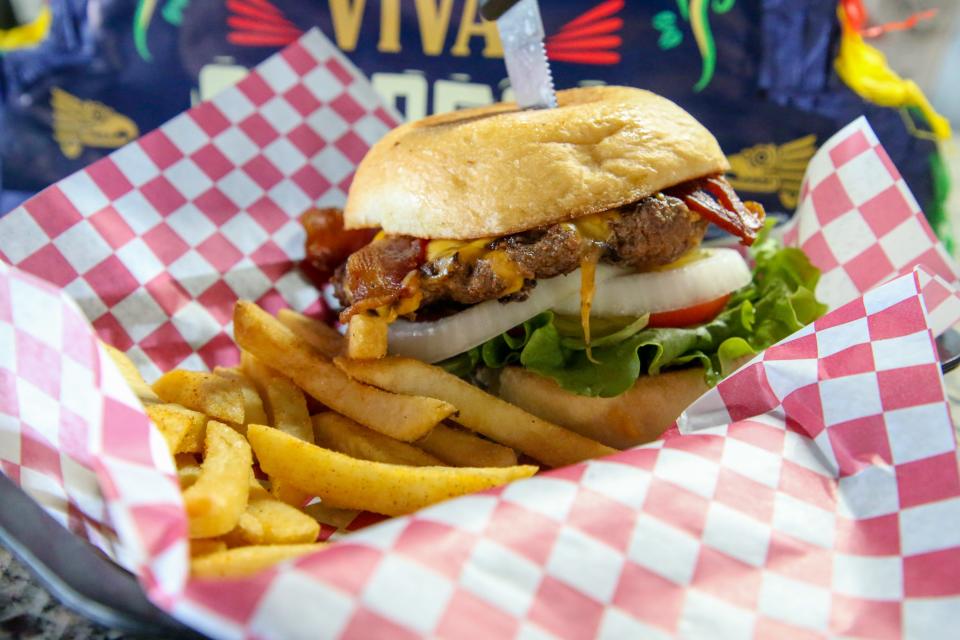 The Bacon Cheddar is House of Burgers & Wings' signature hamburger. It contains bacon, cheddar cheese, lettuce, tomato, onions and pickles.