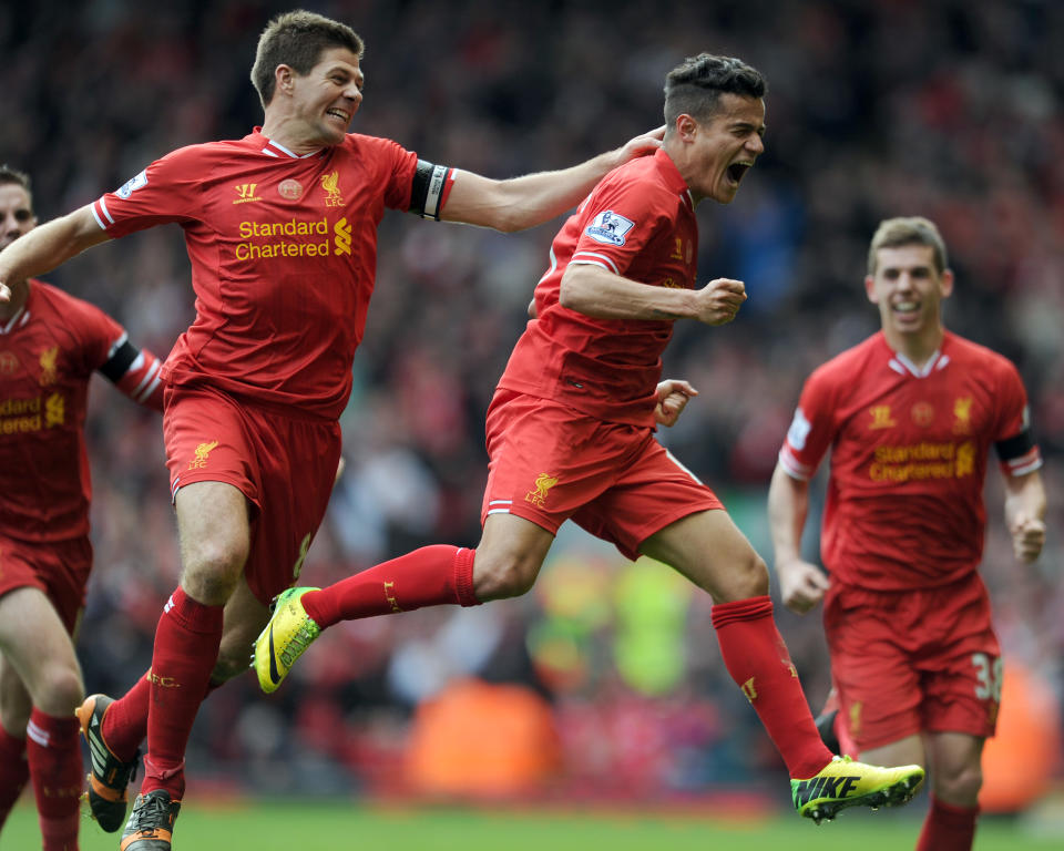 Liverpool's Philippe Coutinho right, celebrates with team-mate Steven Gerrard left, after he scores the third goal of the game for his side during their English Premier League soccer match against Manchester City at Anfield in Liverpool, England, Sunday April. 13, 2014. (AP Photo/Clint Hughes)