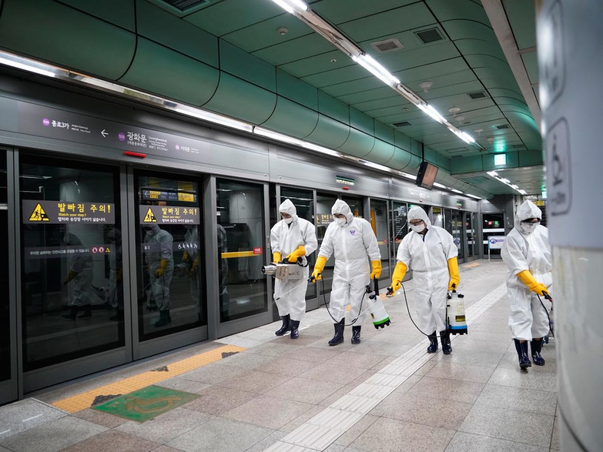 Employees from a disinfection service company sanitize a subway station in Seoul, South Korea, February 28, 2020. REUTERS/Kim Hong-Ji