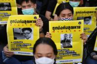 Protesters hold posters with missing students pictures during a protest demanding the resignation of the government, in Bangkok