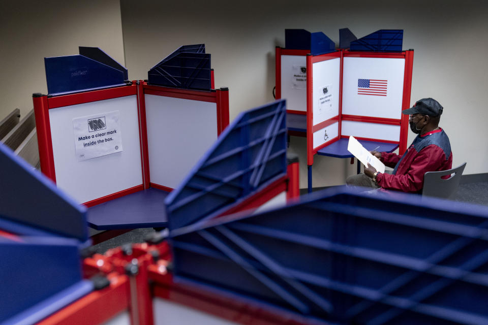 FILE - Cornelius Whiting fills out his ballot at an early voting location in Alexandria, Va., on Sept. 26, 2022. The U.S. does not have a singular entity that tells the nation who is won an election right away. Every state has its own process for counting votes, and news organizations play a key role. The Associated Press is the only news organization in the world that does all of the nation's vote-counting math on election night. (AP Photo/Andrew Harnik, File)