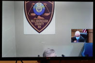 Frank Davis remains mostly hidden as he is arraigned via video while Judge William Lyons presides at right, Thursday, April 8, 2021, at Manchester, N.H. District Court, in connection with sexual abuse allegations at the Sununu Youth Services Center, a state-run youth detention center. Six former staffers at New Hampshire’s state-run youth detention center were arrested Wednesday in connection with the abuse of 11 children over the course of a decade. (AP Photo/Elise Amendola, Pool)