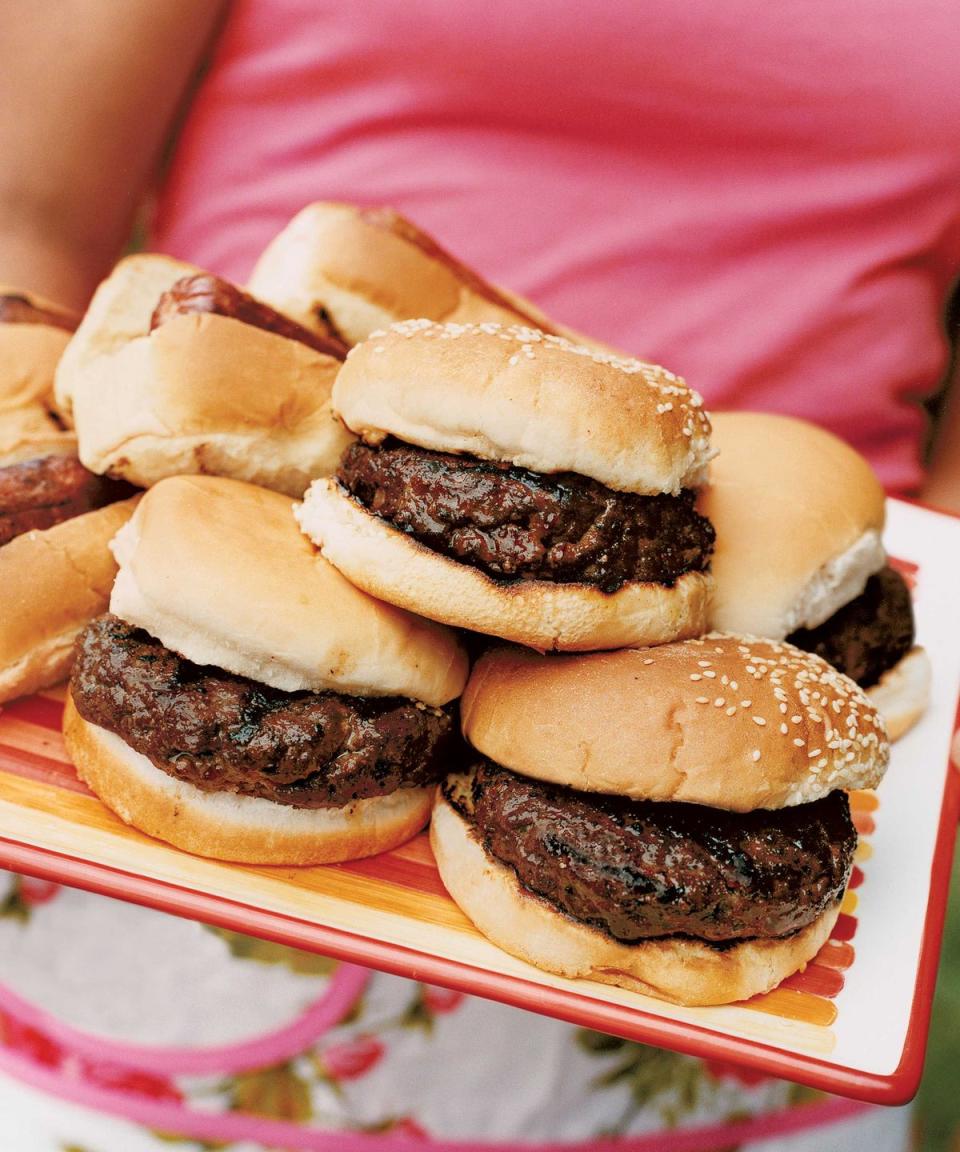 glazed bacon and cheese burgers stacked on a serving tray